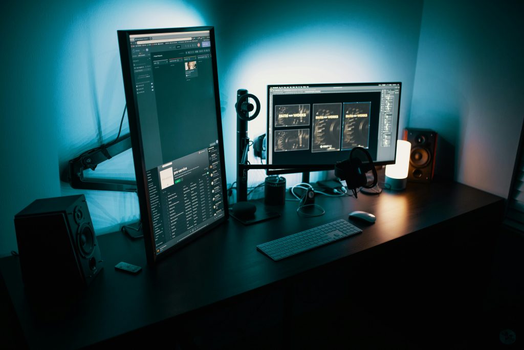 pexels-photo-1714208-1714208 A contemporary office desk featuring a dual monitor setup with stylish lighting, ideal for tech enthusiasts.